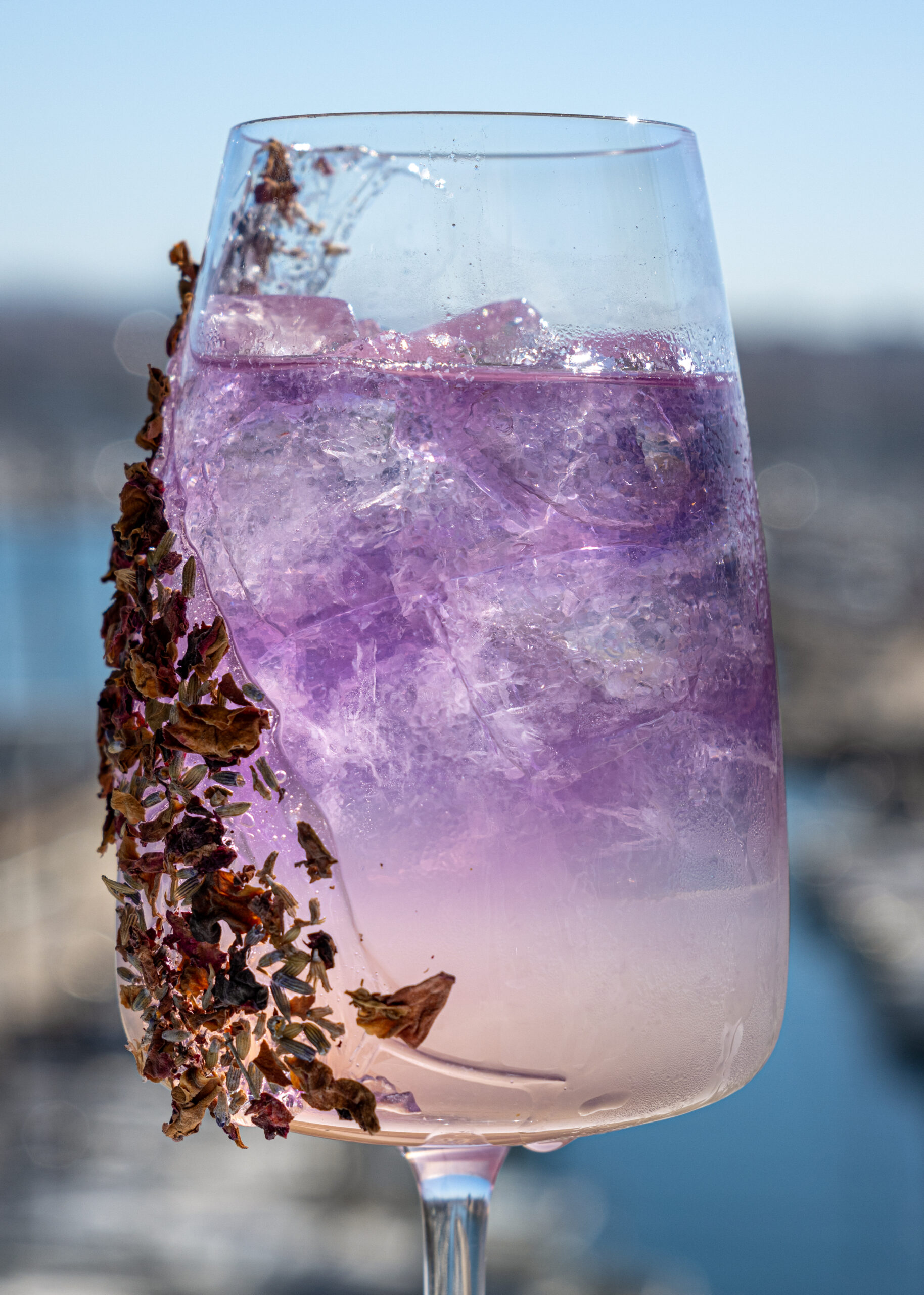 Gros plan sur un cocktail violet avec glace et fleurs séchées au Chalet du Pharo Marseille