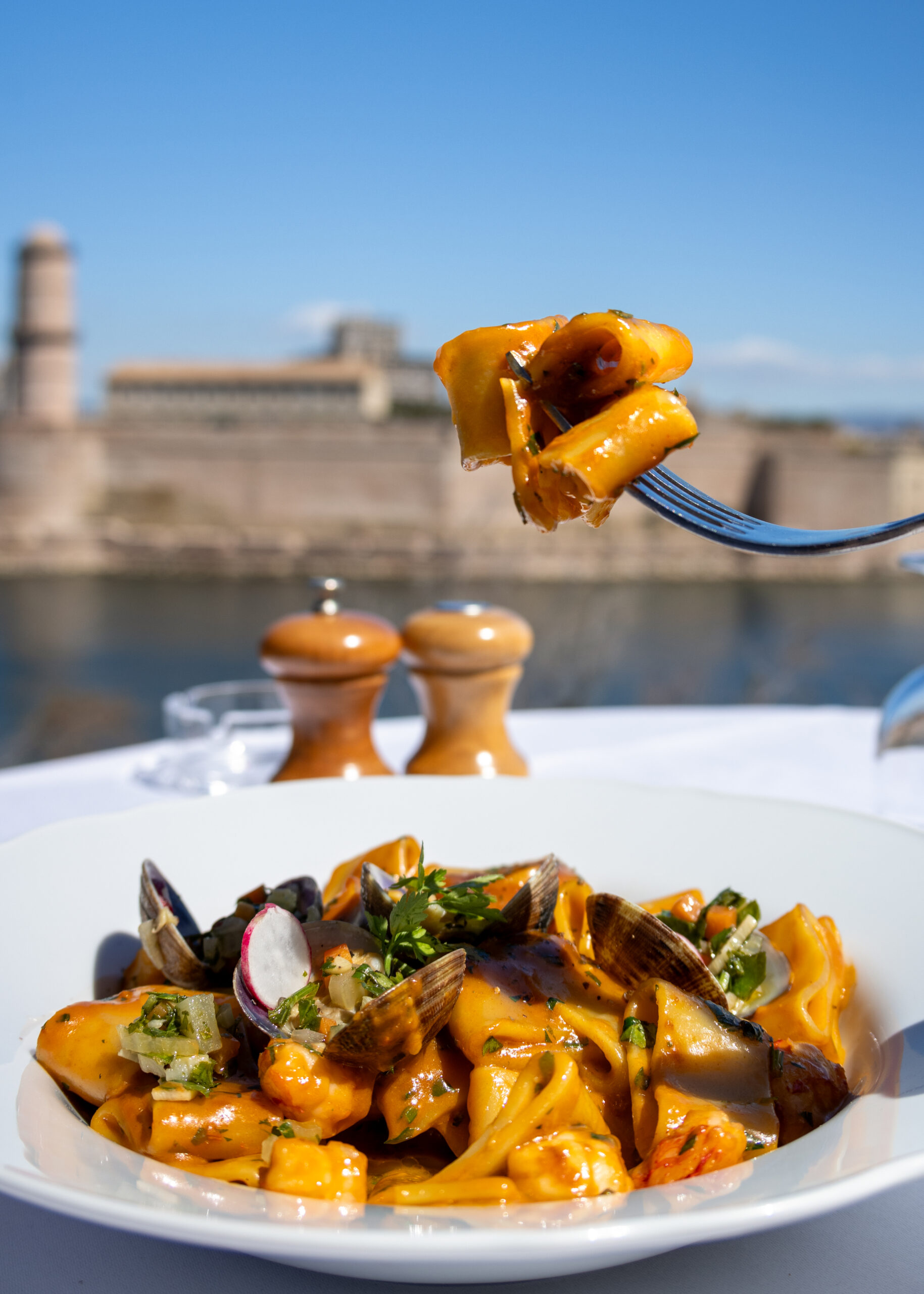 Fourchette de pâtes aux palourdes avec vue sur Marseille et le Vieux-Port